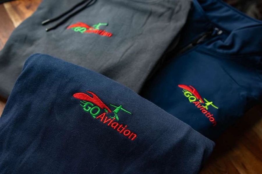 Navy and charcoal GQ Aviation hoodies with the embroidered red and green logo